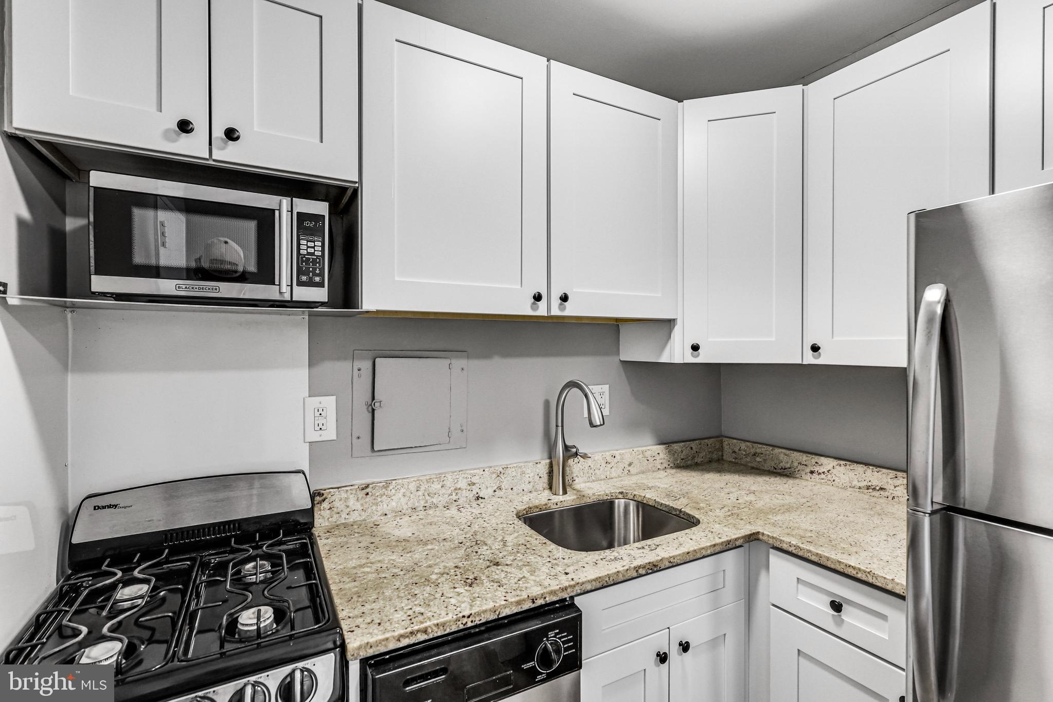 300 M Street Southwest, Unit N102 Washington, DC 20024 - Photo 7 of 53 a kitchen with stainless steel appliances granite countertop a sink stove and refrigerator