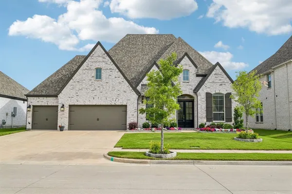 a front view of a house with a yard and trees