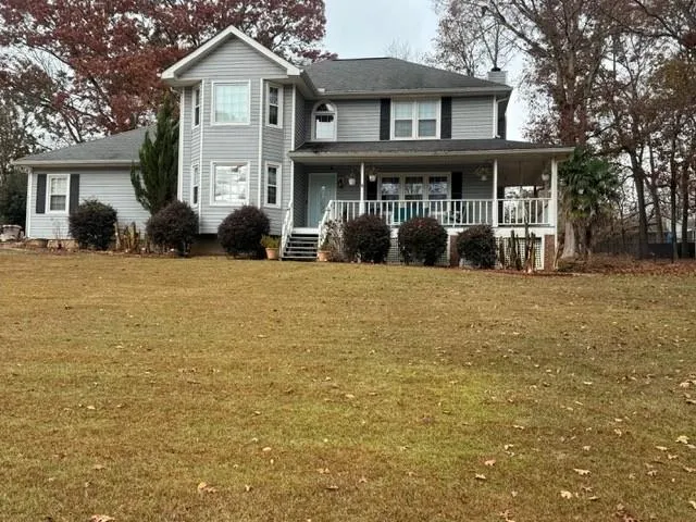 a front view of a house with yard and porch