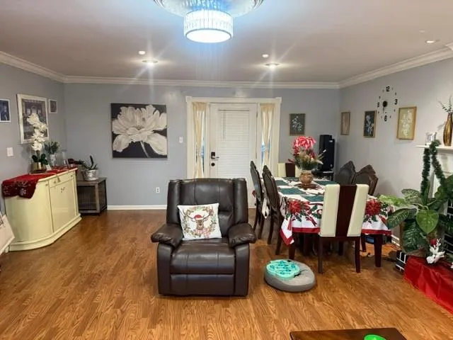 a living room with furniture and a dining table with wooden floor
