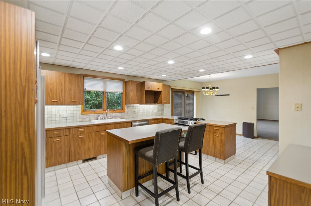 200 Hampshire Road Akron, OH 44313 - Photo 15 of 50 Kitchen featuring wood-finish cabinetry, a large center island, a stainless steel range, and tile flooring