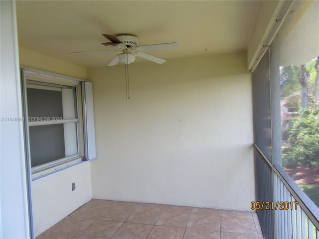 a view of a hallway with a ceiling fan and window