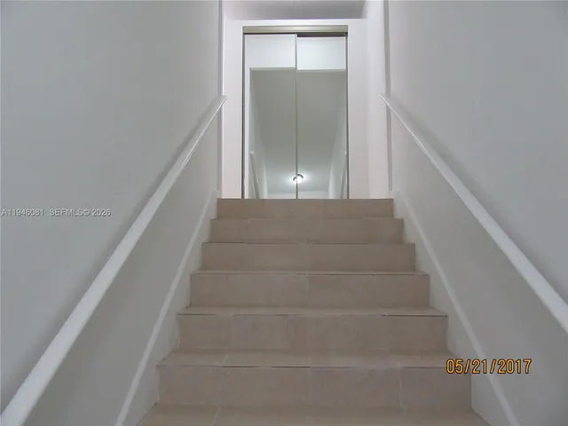 a view of staircase with white walls and window