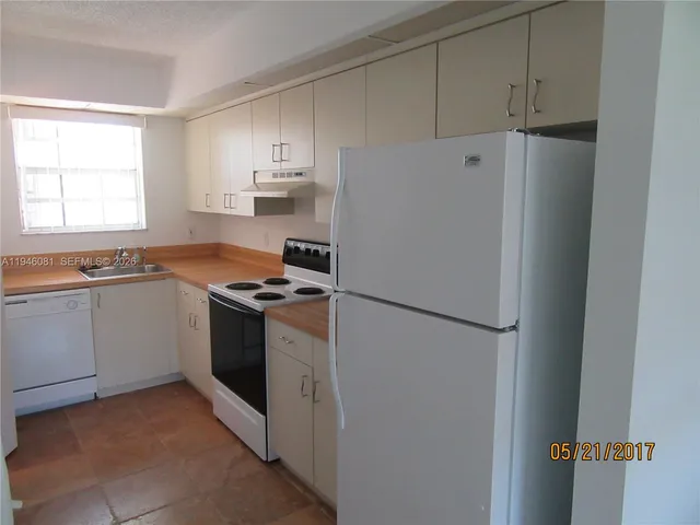 a kitchen with a refrigerator sink stove and cabinets