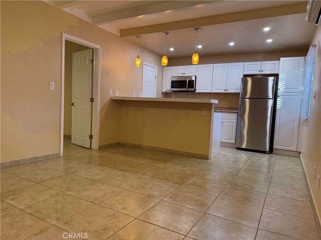 37700 Van Fleet Street, Unit 7 Cathedral City, CA 92234 - Photo 3 of 7 a view of kitchen with stainless steel appliances kitchen island granite countertop a refrigerator and a stove top oven