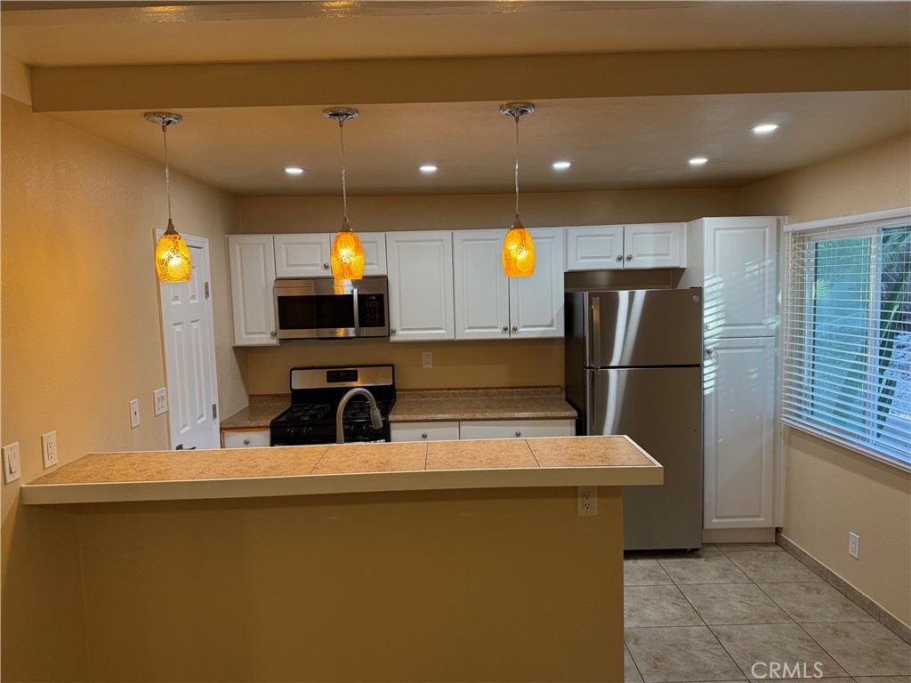 37700 Van Fleet Street, Unit 7 Cathedral City, CA 92234 - Photo 4 of 7 a kitchen with kitchen island a refrigerator and a sink