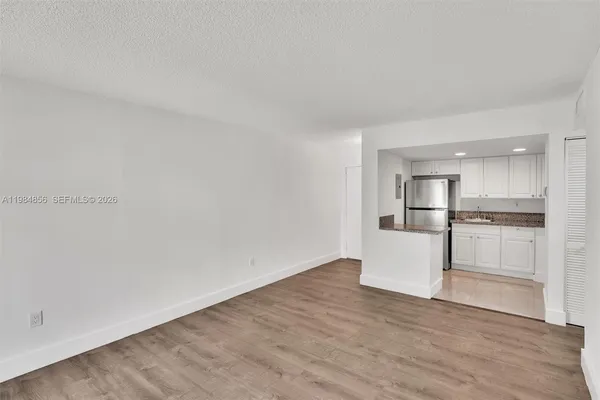 a view of kitchen with white cabinets and white appliances