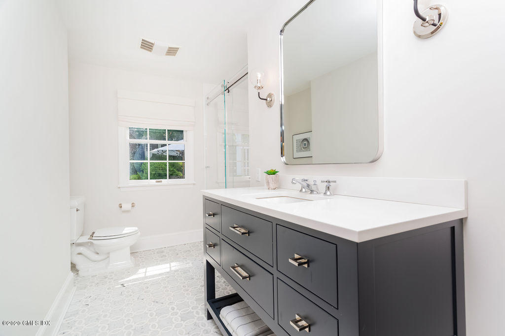 14 Dingletown Road Greenwich, CT 06830 - Photo 30 of 56 a bathroom with a toilet a sink a mirror and a window