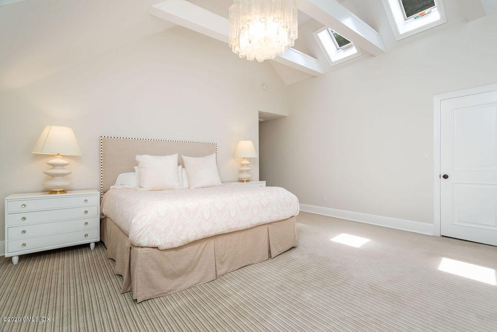 14 Dingletown Road Greenwich, CT 06830 - Photo 38 of 56 a bedroom with a bed and a chandelier