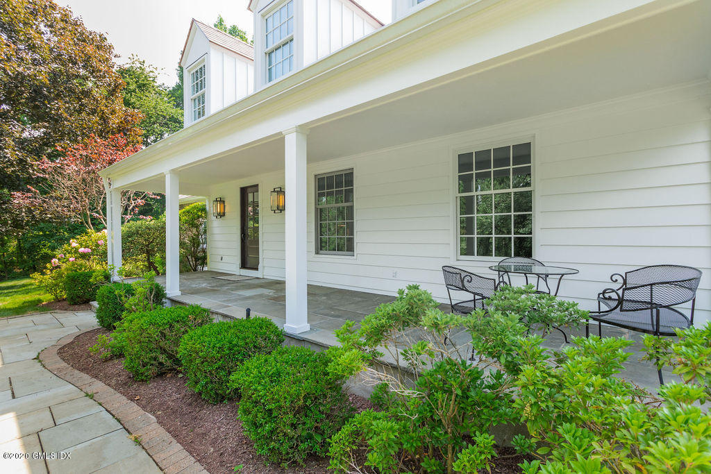 14 Dingletown Road Greenwich, CT 06830 - Photo 6 of 56 front view of a house with potted plants and a bench