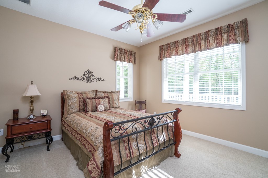 130 Orchard Ridge Drive Forsyth, GA 31029 - Photo 14 of 24 a bedroom with a bed and a chandelier