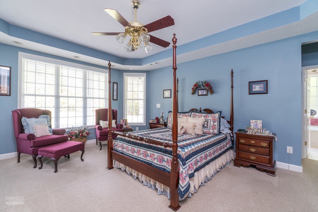 130 Orchard Ridge Drive Forsyth, GA 31029 - Photo 15 of 24 a bedroom with a bed and a chandelier