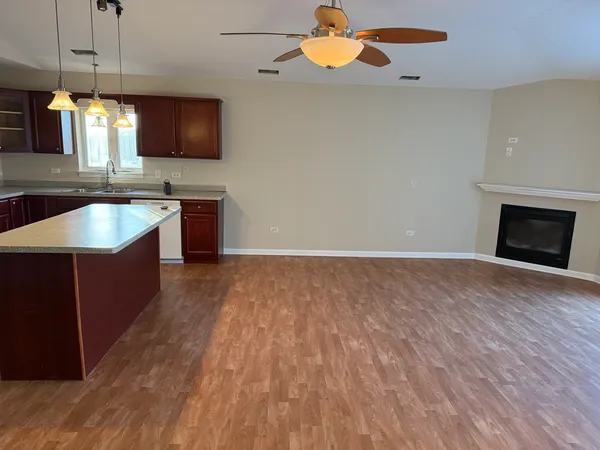 a large kitchen with stainless steel appliances granite countertop a sink a stove top oven a counter space and cabinets