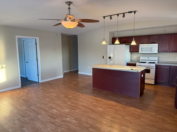 a kitchen with kitchen island stainless steel appliances a sink stove and refrigerator