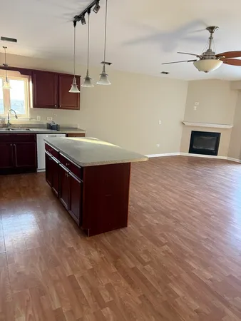 a kitchen with stainless steel appliances granite countertop a sink a stove and a wooden floors