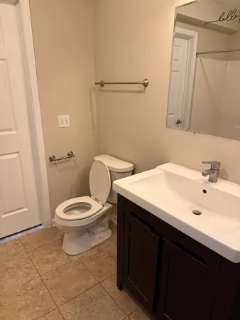 a bathroom with a toilet sink and mirror