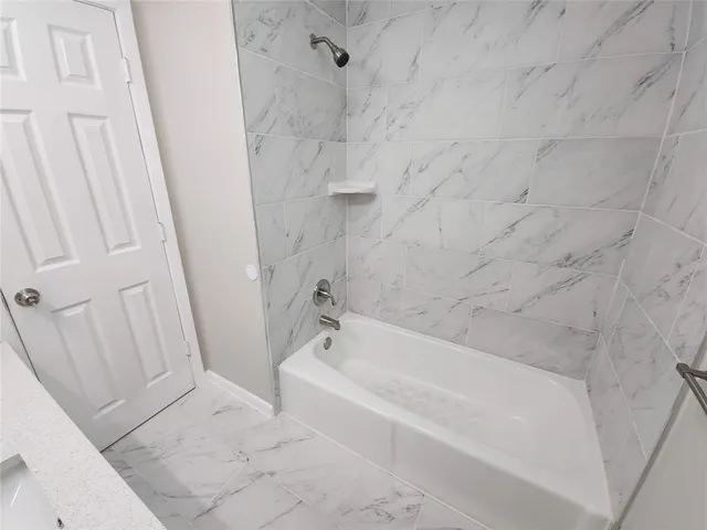 a bathroom with bathtub and shower