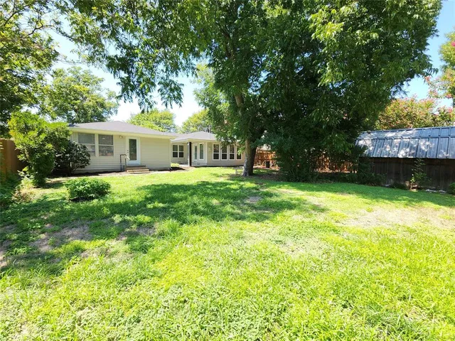 a view of a house with a yard and a patio