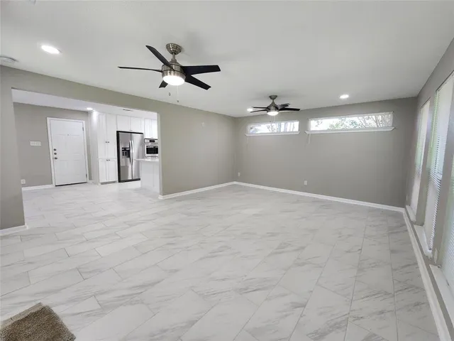 a view of a livingroom with a ceiling fan and window