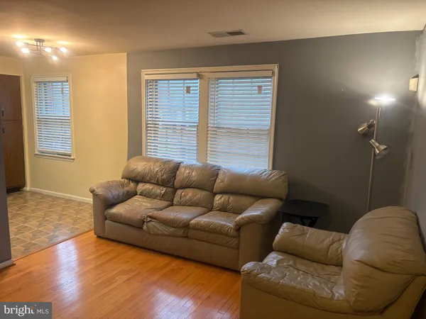 a living room with furniture window and a wooden floor