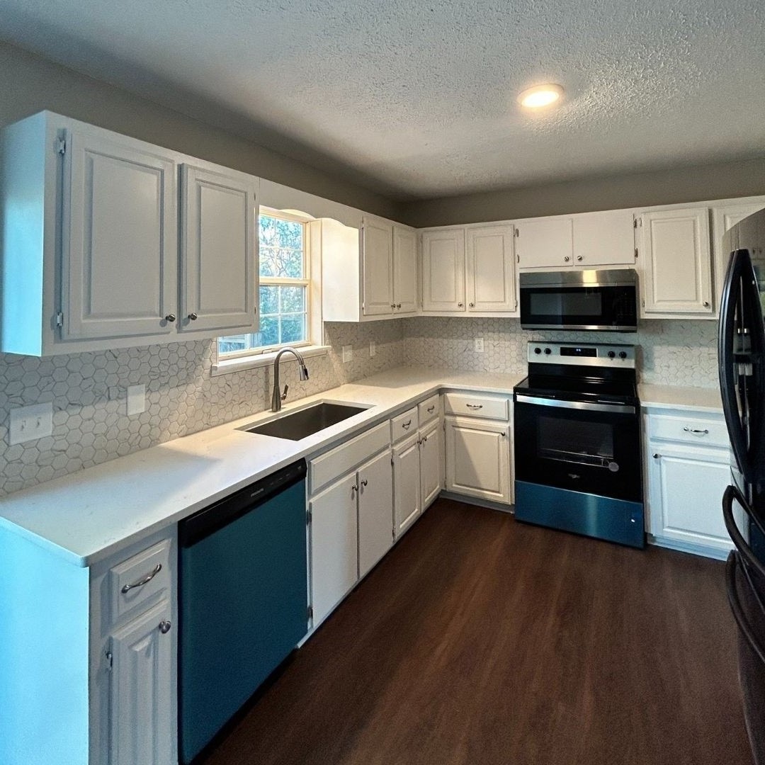 a kitchen with sink a microwave and cabinets