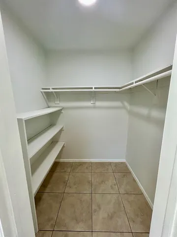 a view of walk in closet with empty racks