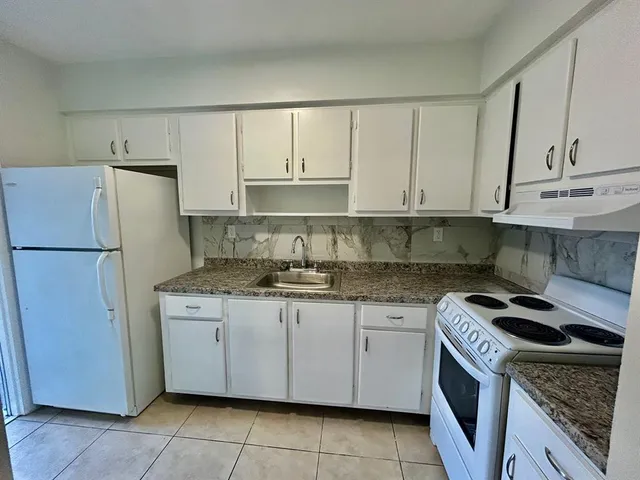 a kitchen with a stove sink and refrigerator