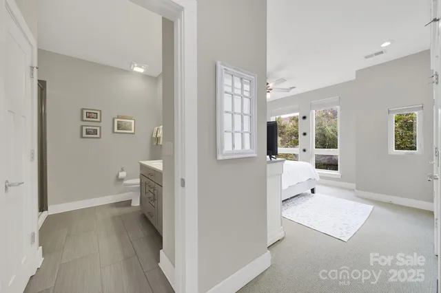 a view of a hallway with bathroom and wooden floor