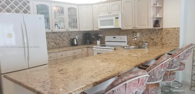 a kitchen with stainless steel appliances granite countertop a sink and a refrigerator