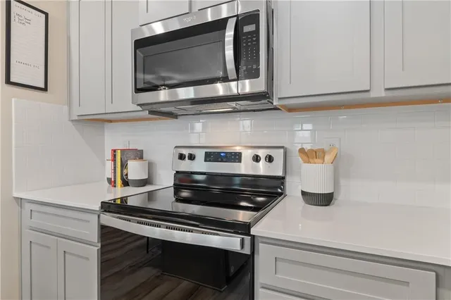 a kitchen with stainless steel appliances granite countertop a stove and a microwave