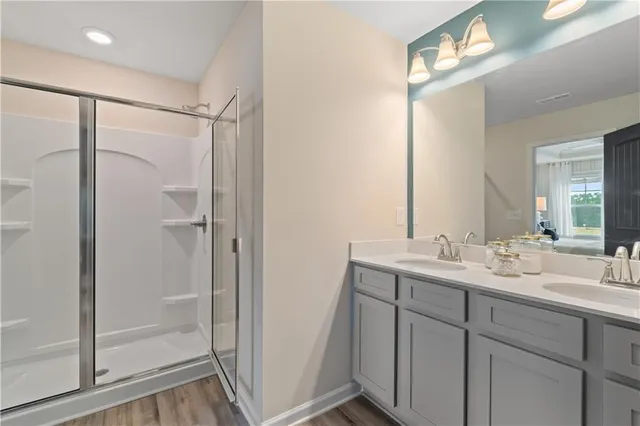a bathroom with a double vanity sink mirror and shower