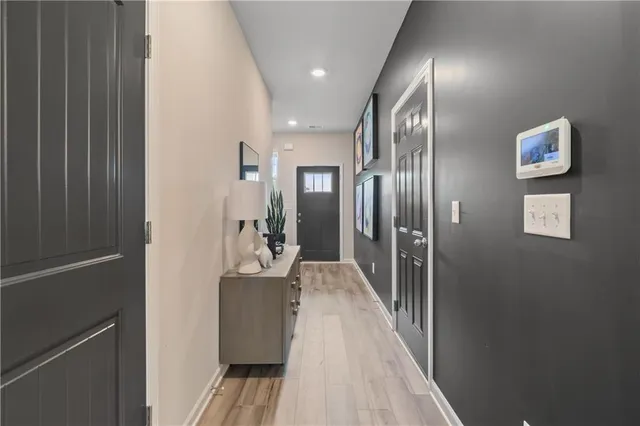a view of a hallway with wooden floor and windows