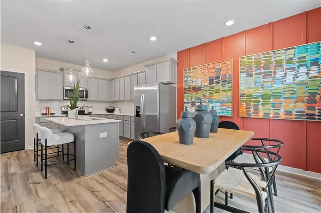 a kitchen with a table chairs refrigerator and cabinets