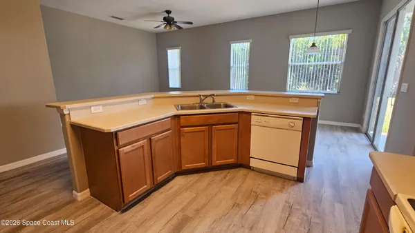 a utility room with sink dryer and wooden floor