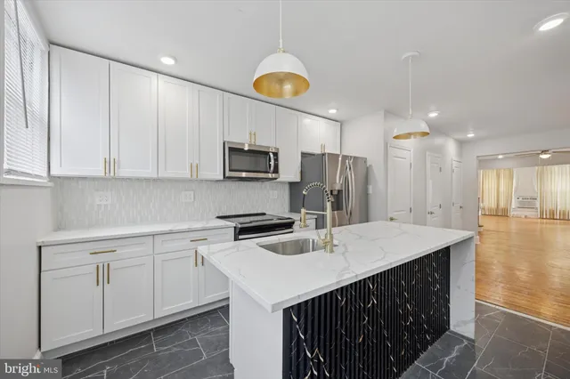 a kitchen that has a lot of cabinets and wooden floor