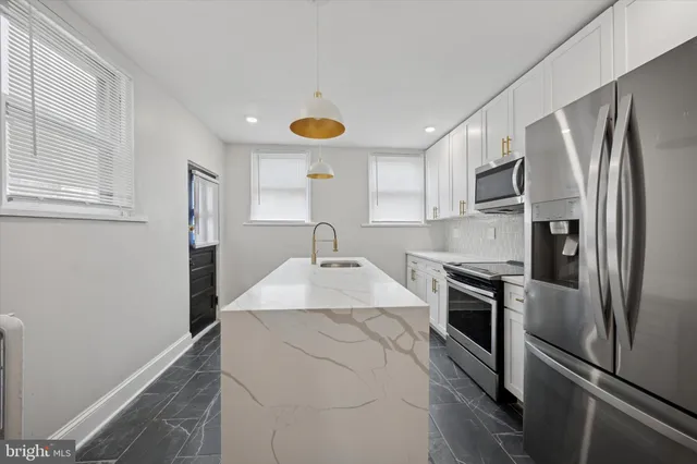 a kitchen with stainless steel appliances granite countertop a refrigerator sink and stove