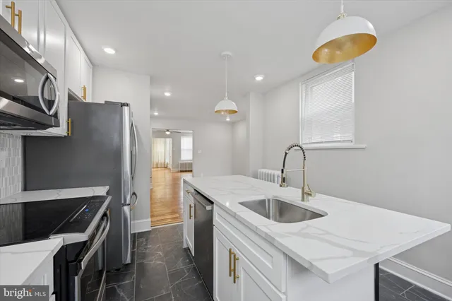 a kitchen with stainless steel appliances granite countertop a sink a stove and a refrigerator