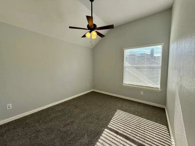 a view of a room with a ceiling fan and a window