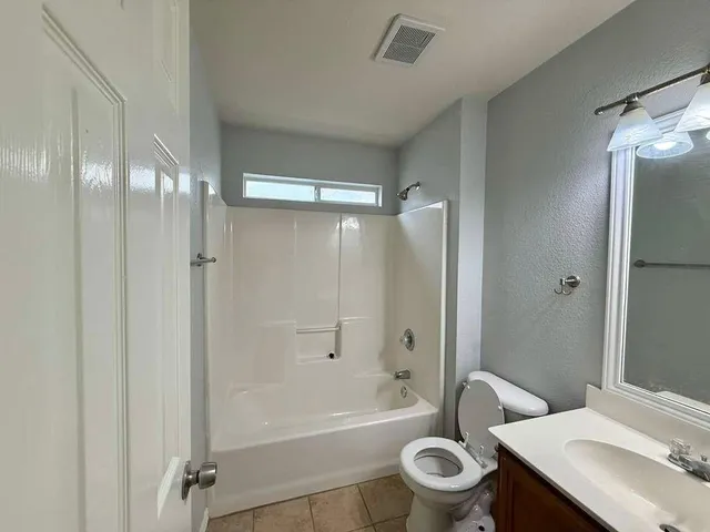 a bathroom with a sink toilet vanity and shower