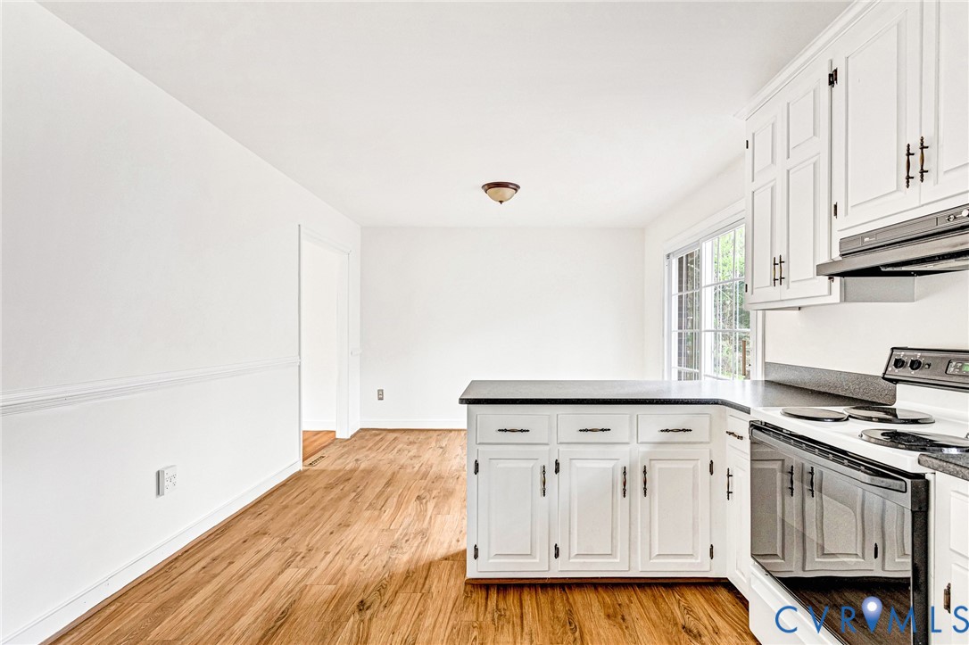 9107 Mossy Brook Road Mechanicsville, VA 23116 - Photo 9 of 30 Kitchen with white electric stove, a peninsula, wh