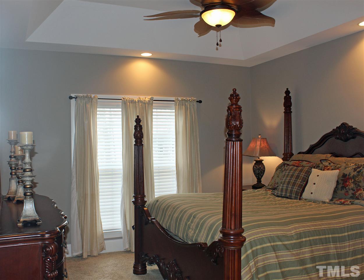 6904 Field Hill Road Raleigh, NC 27603 - Photo 15 of 25 a bedroom with a bed and a chandelier