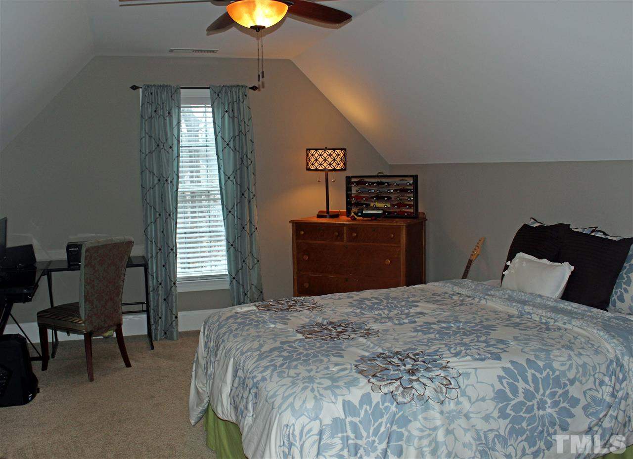6904 Field Hill Road Raleigh, NC 27603 - Photo 21 of 25 a bedroom with a bed and a chandelier