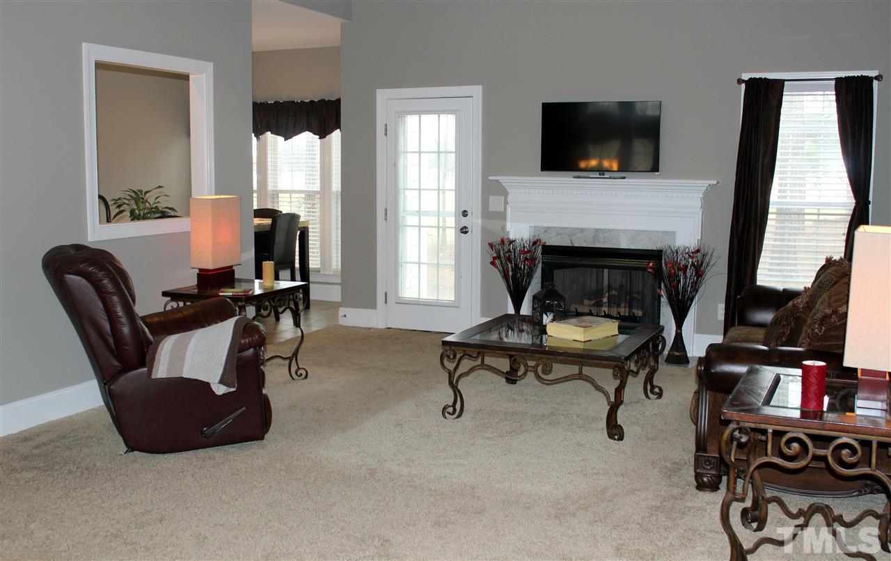6904 Field Hill Road Raleigh, NC 27603 - Photo 5 of 25 a living room with furniture a flat screen tv and a fireplace