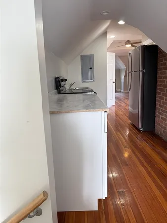 a view of a refrigerator in kitchen and an empty room