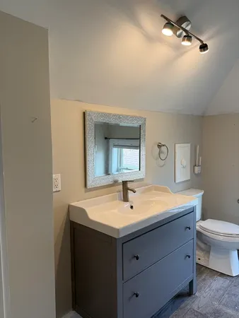 a bathroom with a sink toilet and mirror