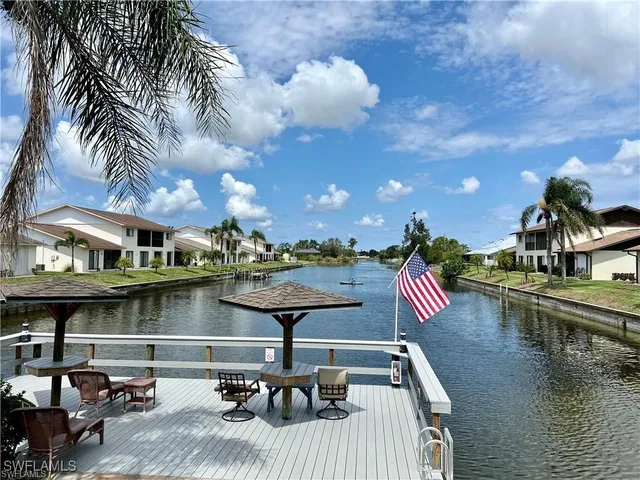 a view of a swimming pool with lawn chairs and a potted plants