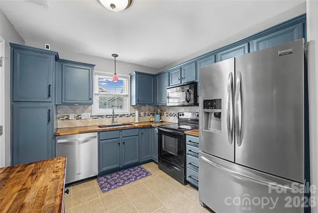 a kitchen with granite countertop a refrigerator stove and microwave