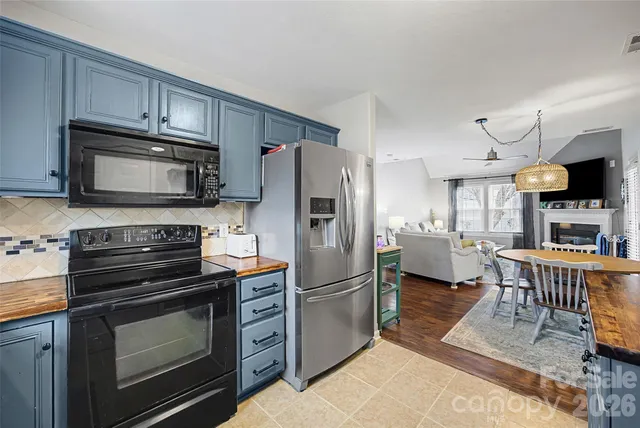 a living room with stainless steel appliances kitchen island granite countertop furniture and a wooden floors