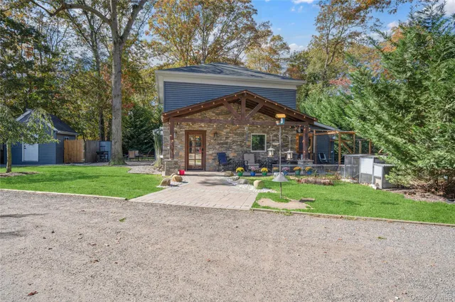 a view of a house with a big yard and large trees