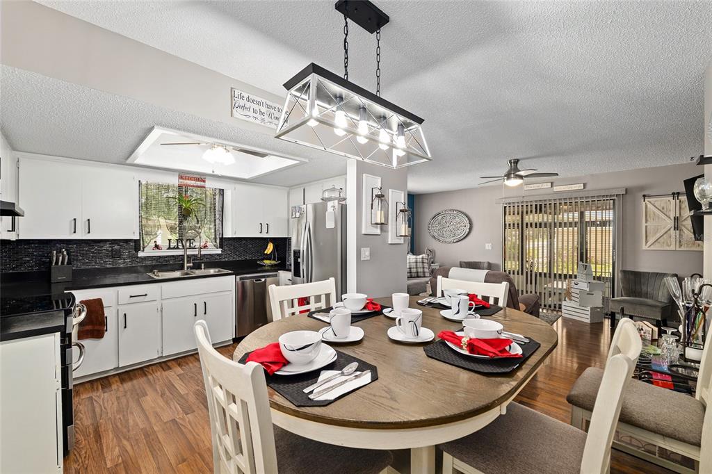 10182 Southwest 88th Court Ocala, FL 34481 - Photo 11 of 31 a view of a dining room with furniture a kitchen and chandelier